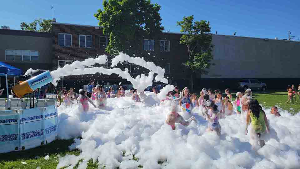 People enjoying a foam party with blue lighting