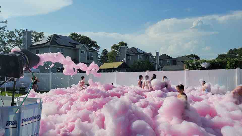 People dancing in foam with colorful lights